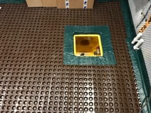 Basement sump pump in the floor surrounded by floor membrane