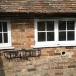20160607_100651 Exterior of the side of a cottage with hanging baskets on the walls