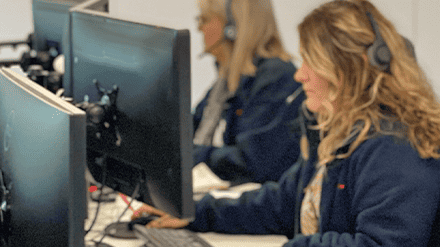 Two female Timberwise customer service assistants working at their desks with headsets on
