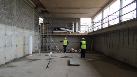 Timberwsie workmen in a basement preparing for damp proofing