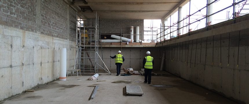 Timberwsie workmen in a basement preparing for damp proofing
