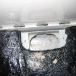 Closeup of perimeter drain channel inspection port in basement