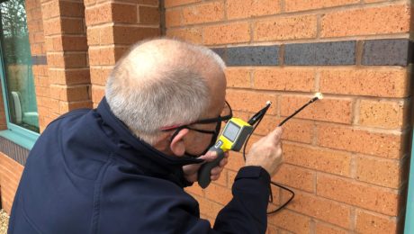 Surveyor carrying out external cavity wall survey