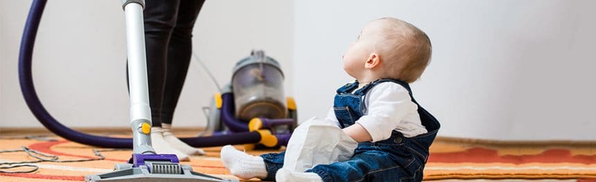 Child on floor with a vacuum cleaner