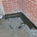 Waterproof coating being applied to bottom of outside wall