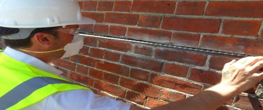 Engineer carrying out crack stitching on external wall