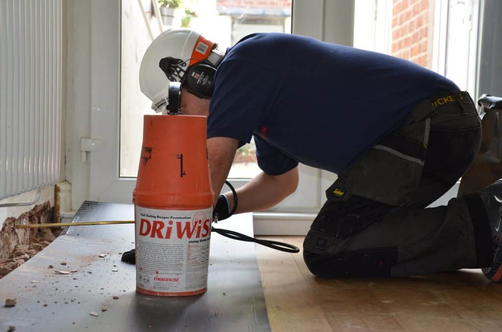 Technician applying a damp proof course