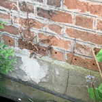 Closeup of holes drilled into brickwork