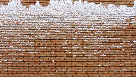 A layer of frozen ice and snow on a brick wall