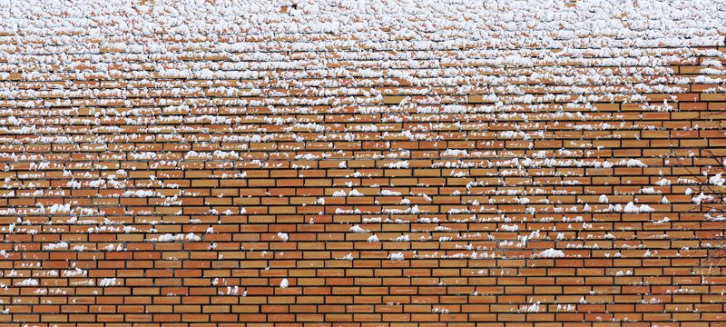 A layer of frozen ice and snow on a brick wall
