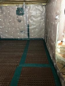 Walls and floor in a basement covered in cavity drain membrane
