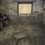 Dark damp basement room with a boarded up window