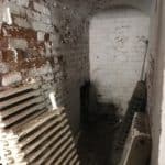 Unused area of the basement with disused radiators leaning against the wall