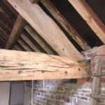 Timber roof beam with signs of woodworm