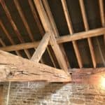Timber roof beam with signs of woodworm