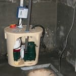Closeup of sump pump being replaced in a basement