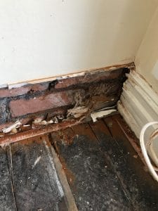 Removed skirting boards to expose damage to brickwork