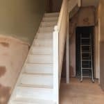 White staircase in a basement with ladders in the background White staircase in a basement with ladders in the background