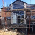 A new build property with scaffolding on the outside and a basement room
