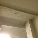 Closeup of basement ceiling showing signs of dampness