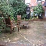 Wooden patio furniture on a stone patio