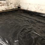 Basement with black tarpaulin covering the floor