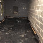 Basement floor covered with tarpaulin in preparation for waterproofing