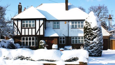 Exterior view of house and garden covered in a thick layer of snow