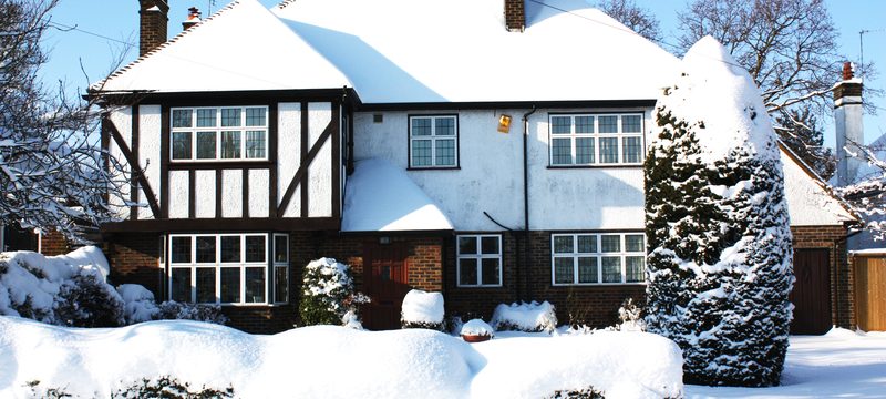 Exterior view of house and garden covered in a thick layer of snow
