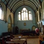 Image inside church building with pews facing the altar
