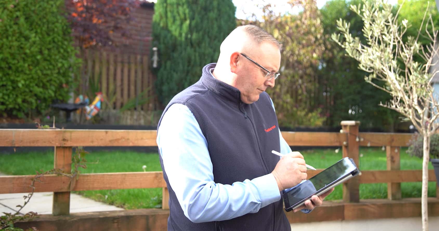 Surveyor stood with checkboard looking for external defects on house exterior