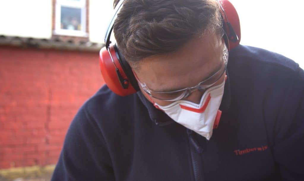 Closeup of Timberwise engineer with safety glasses on and protective headphones and dust mask