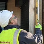 Technician with spirit level on timber beam in Fallowfield for Timberwise Case Study