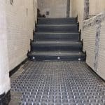 Black waterproofing membrane applied to the stairs in a basement