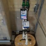 Closeup of a sump and pump installed in a basement