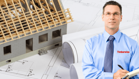Man with plans and a half build house behind him