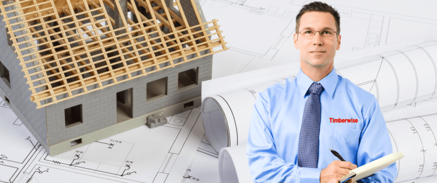 Man with plans and a half build house behind him