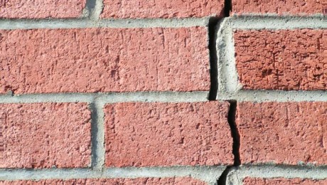 Closeup of a large structural crack in a brick wall