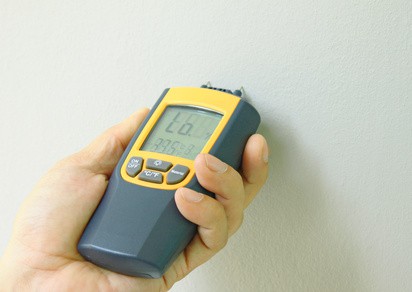 surveyor using damp meter to detector damp